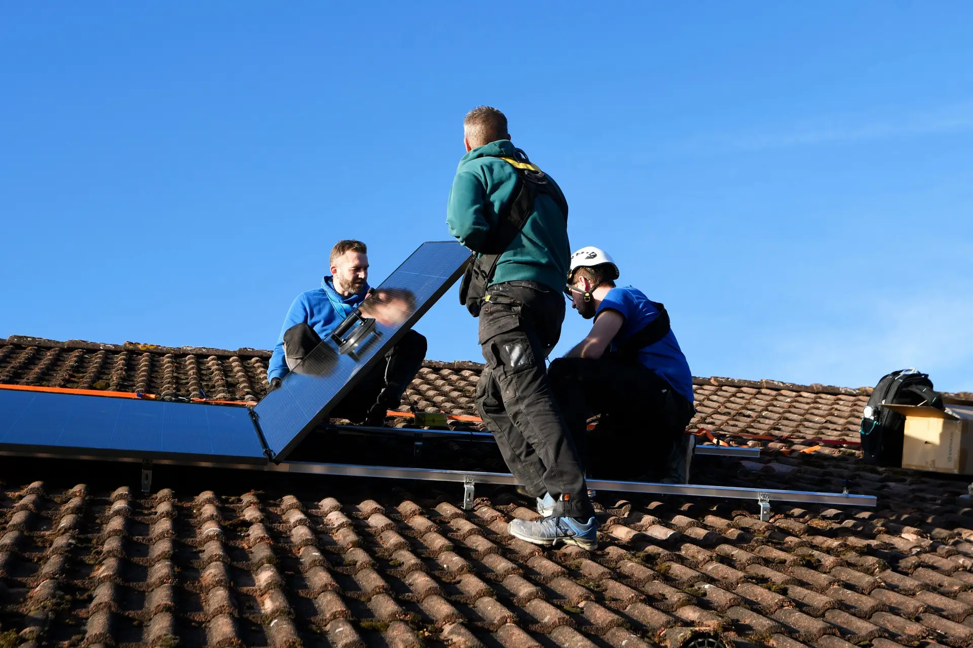 Nos installateurs de panneaux photovoltaïques en train de fixer le panneau au rail