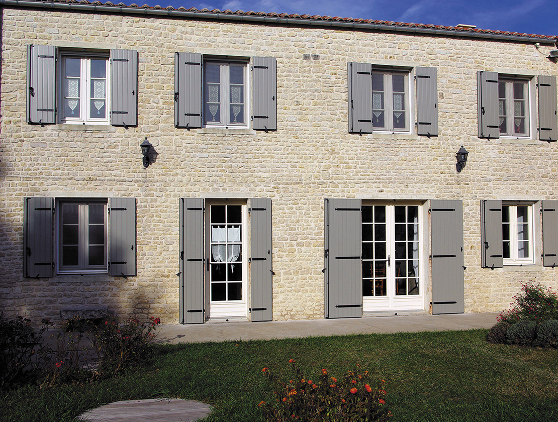 Grandes maison en pierre avec des volets battants gris